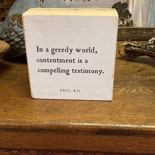 In a greedy world wooden sign